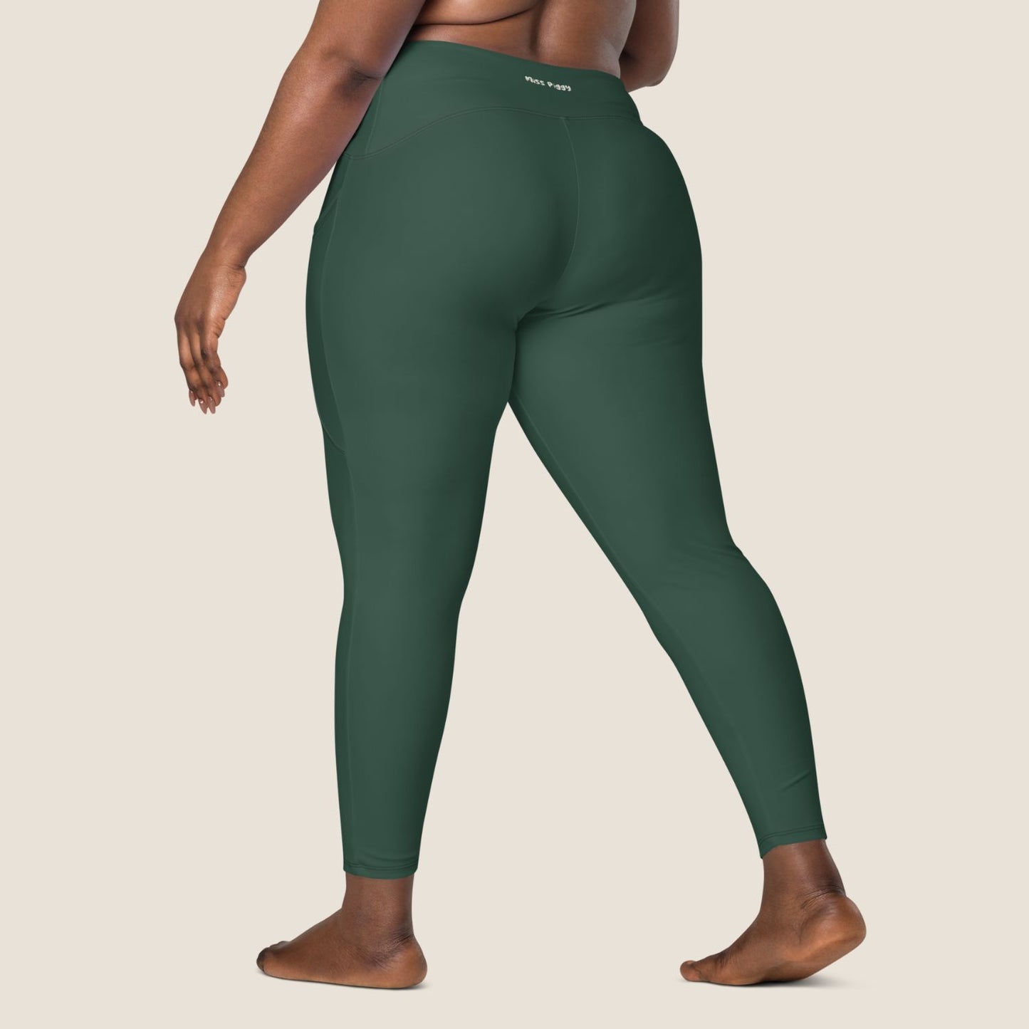 DEEP MOVE Leggings in forest green with off-white print, made from recycled materials.