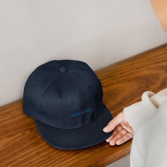 Navy blue cap with 'made to feel' text