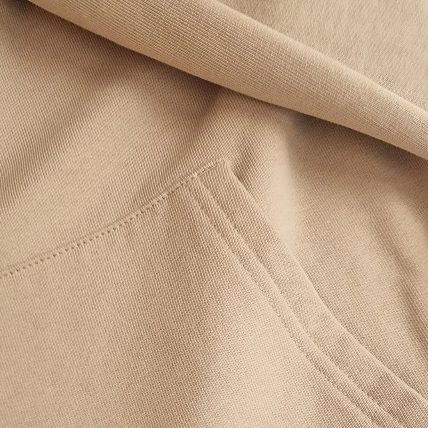 Close-up of beige fabric with a visible seam