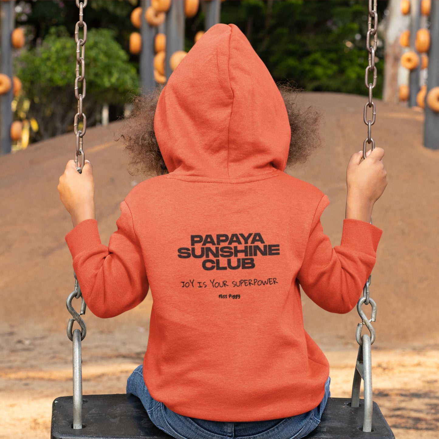 Child wearing the SUN CLUB hoodie in a relaxed fit, made from organic cotton and recycled polyester. Unisex design with soft texture and natural tone, photographed against a light, playful background.