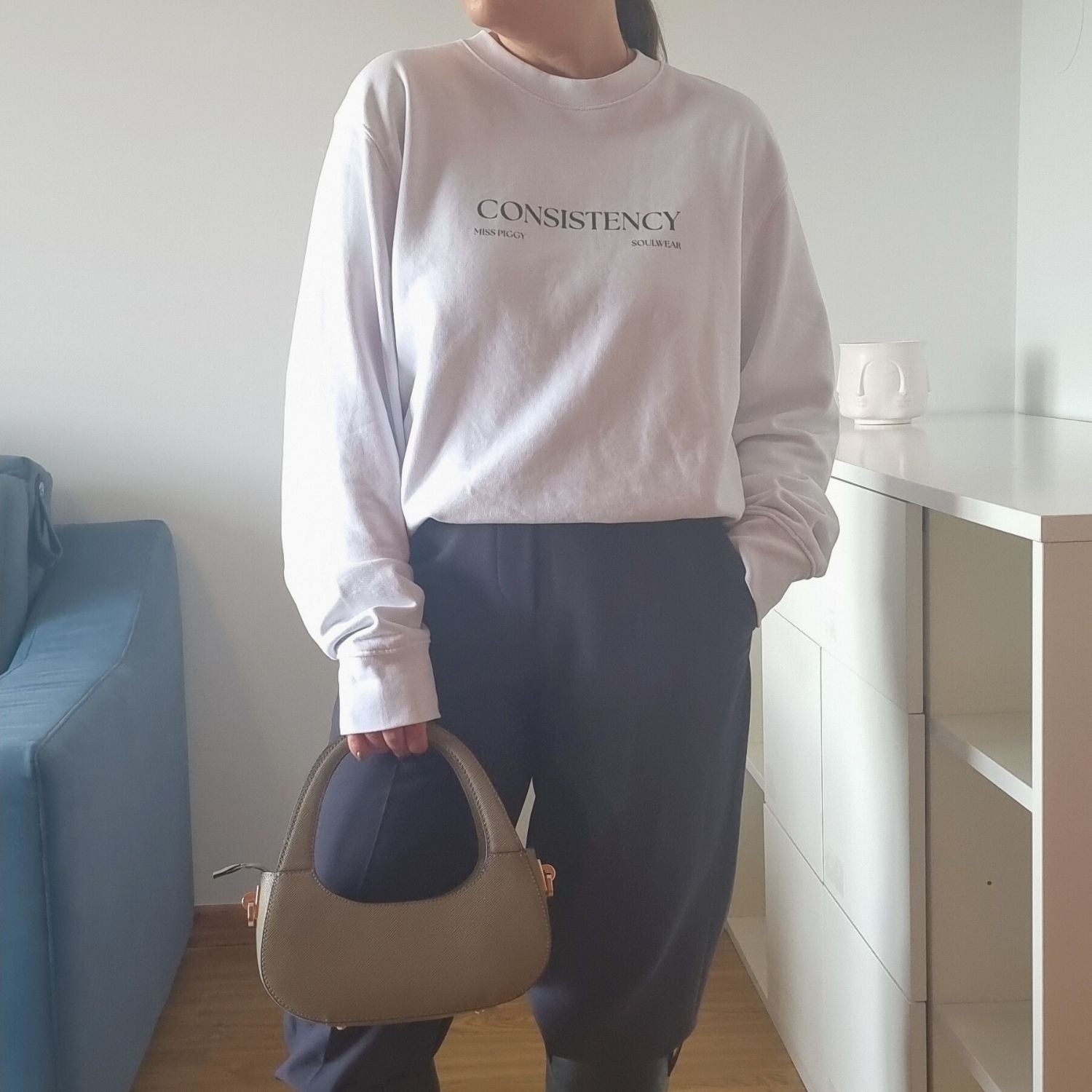 Unisex CONSISTENCY Organic Sweater in white with green print, minimalist sustainable design by Miss Piggy.