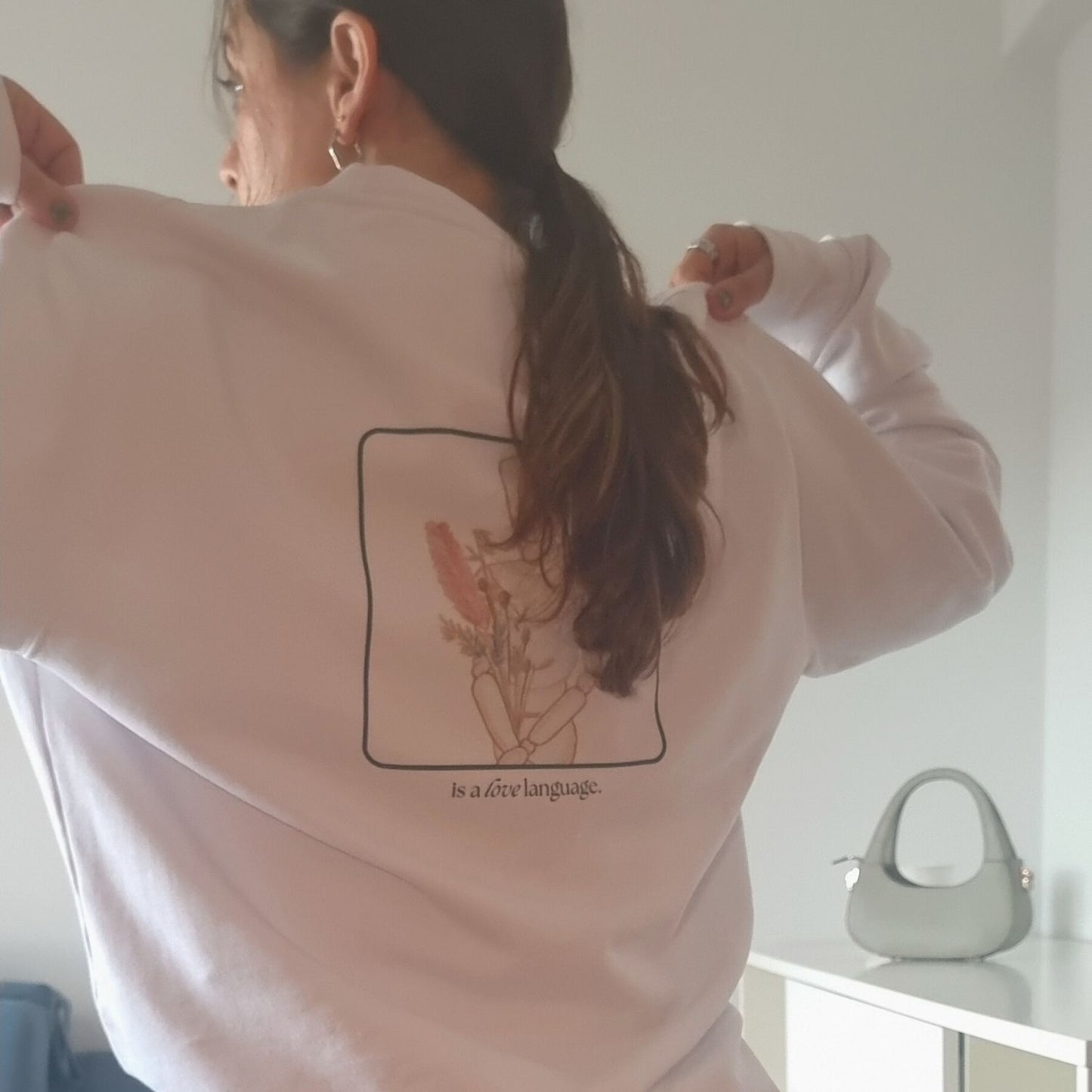 Unisex CONSISTENCY Organic Sweater in white with green print, minimalist sustainable design by Miss Piggy.