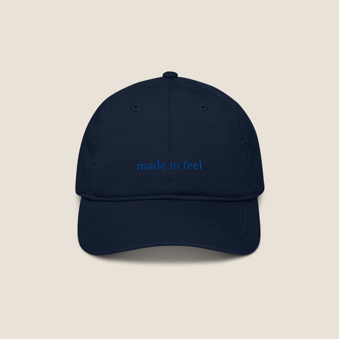 Navy blue cap with 'made to feel' text 