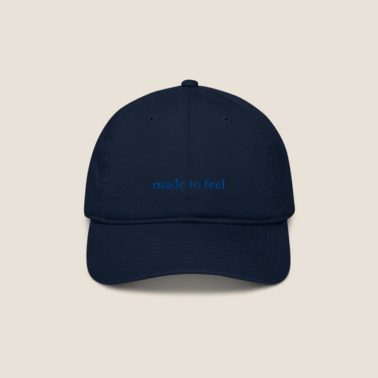 Navy blue cap with 'made to feel' text 
