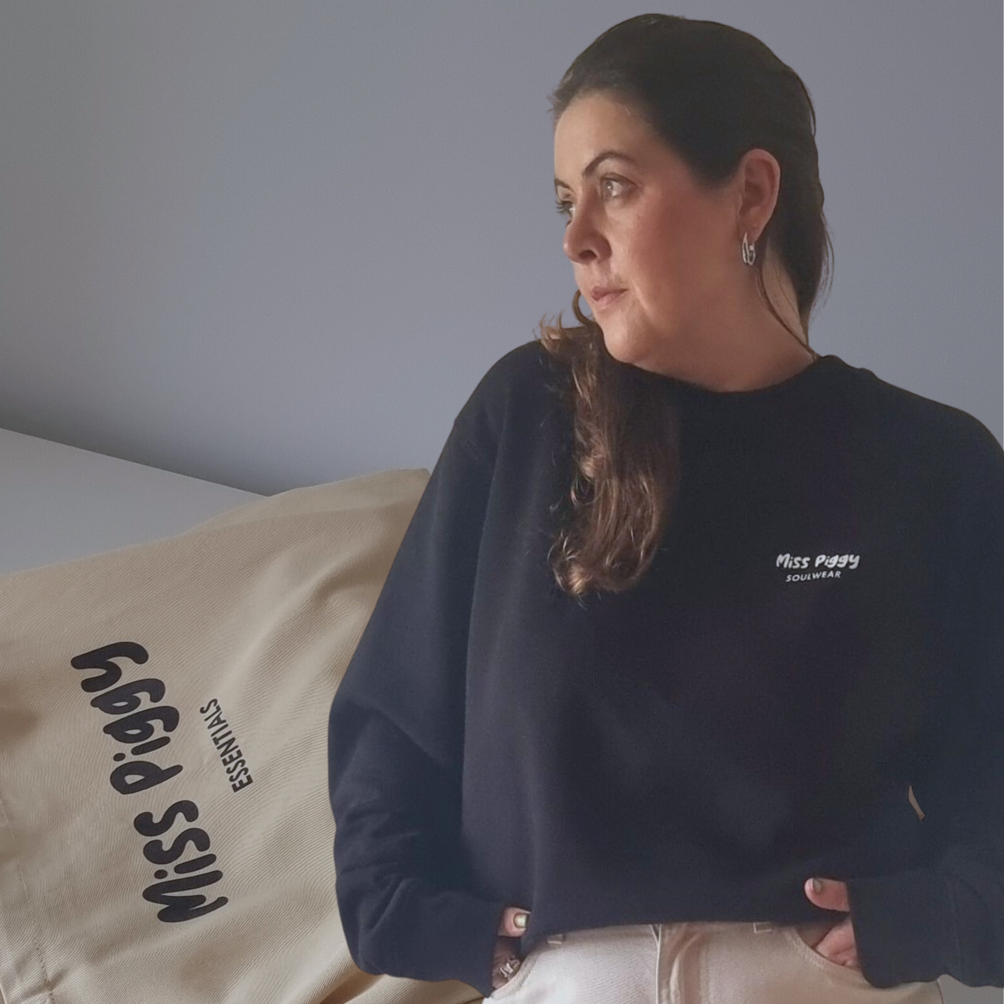 Founder wearing Protocol organic sweater in black, standing next to  Carry shopper in oyster beige on a plain background