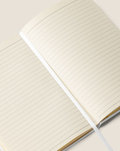 A durable Notebook UltraHyde hardcover, 80 lined cream pages, a matching elastic closure, and a ribbon bookmark with motivational quote.