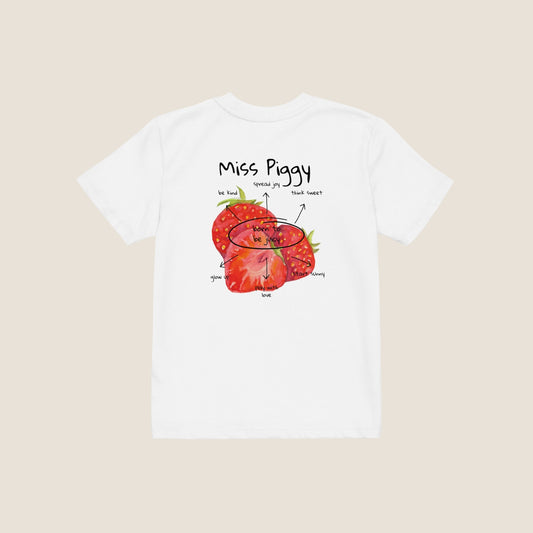 Two kids wearing the JUICY t-shirt in white. Unisex organic cotton design with soft texture and playful energy, shown in a light and joyful setting.