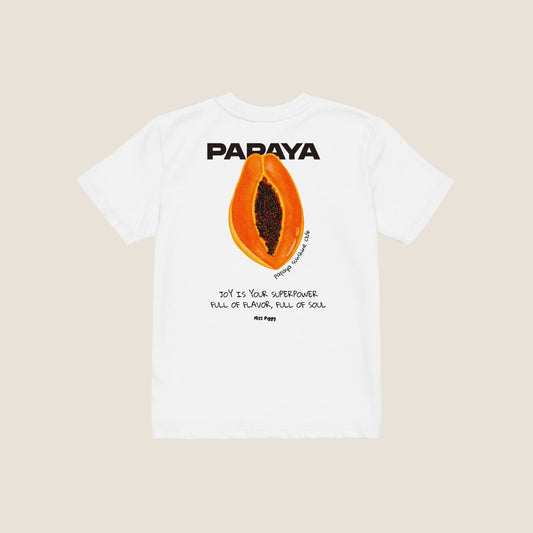 Child wearing the PAPAYA t-shirt in white. Unisex organic cotton design with soft texture and playful energy, shown in a light and joyful setting.