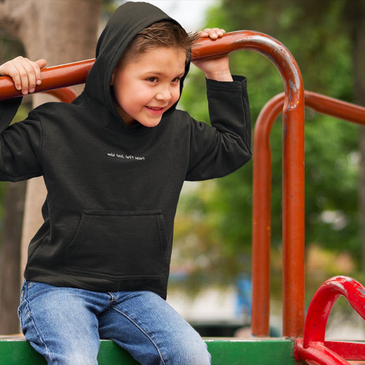 Child wearing the SOUL SNUG hoodie in a relaxed fit, made from organic cotton and recycled polyester. Unisex design with soft texture and natural tone, photographed against a light, playful background