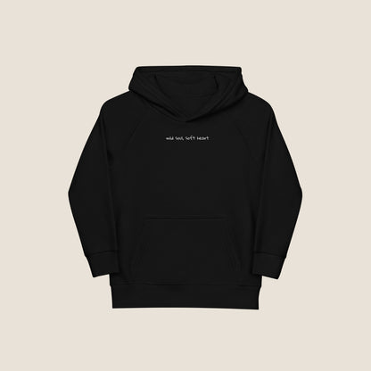 Child wearing the SOUL SNUG hoodie in a relaxed fit, made from organic cotton and recycled polyester. Unisex design with soft texture and natural tone, photographed against a light, playful background